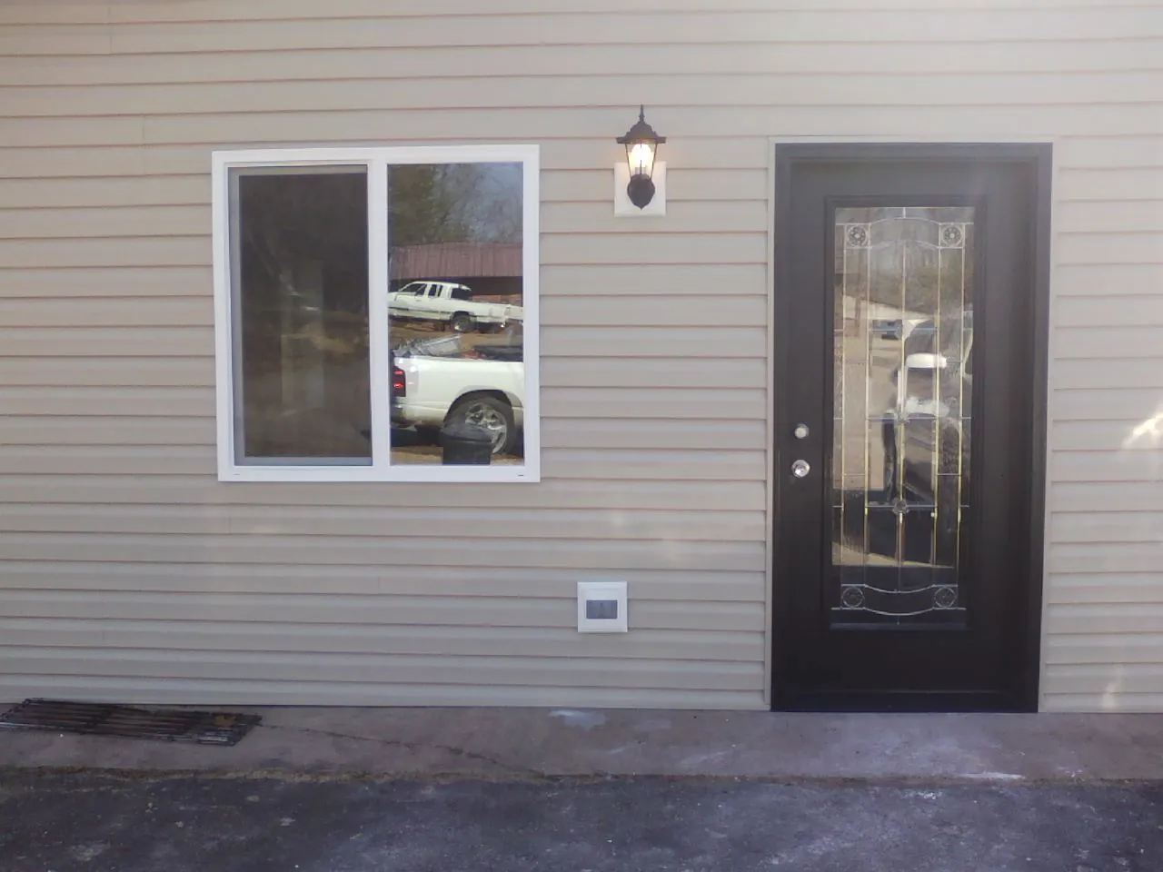 New siding, window and entry door on the side of an addition in Martin City
