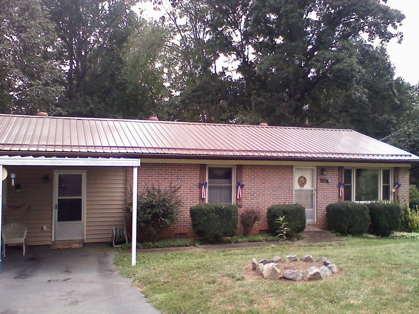 Bronze metal roof and carport on a brick ranch home — Roof Repair work by our crew in Martin City