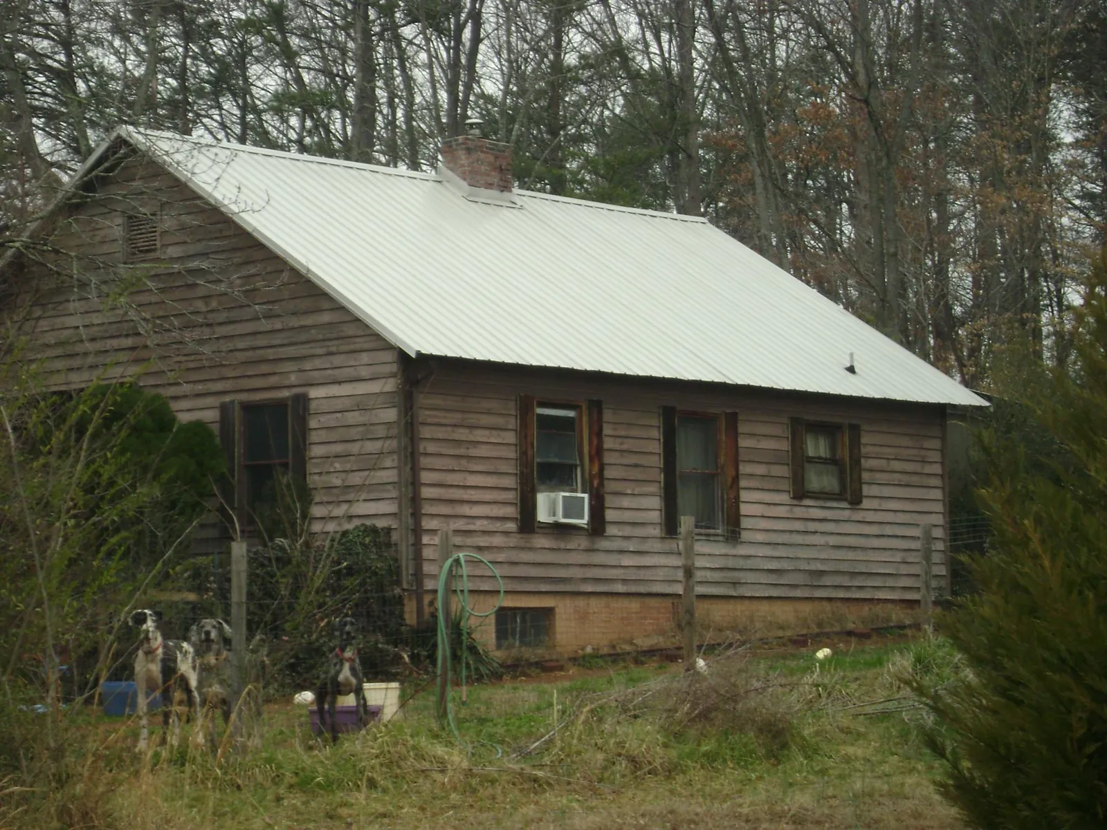 White metal roof on an old wood sided farmhouse, from a Metal Roof Installation job in Martin City